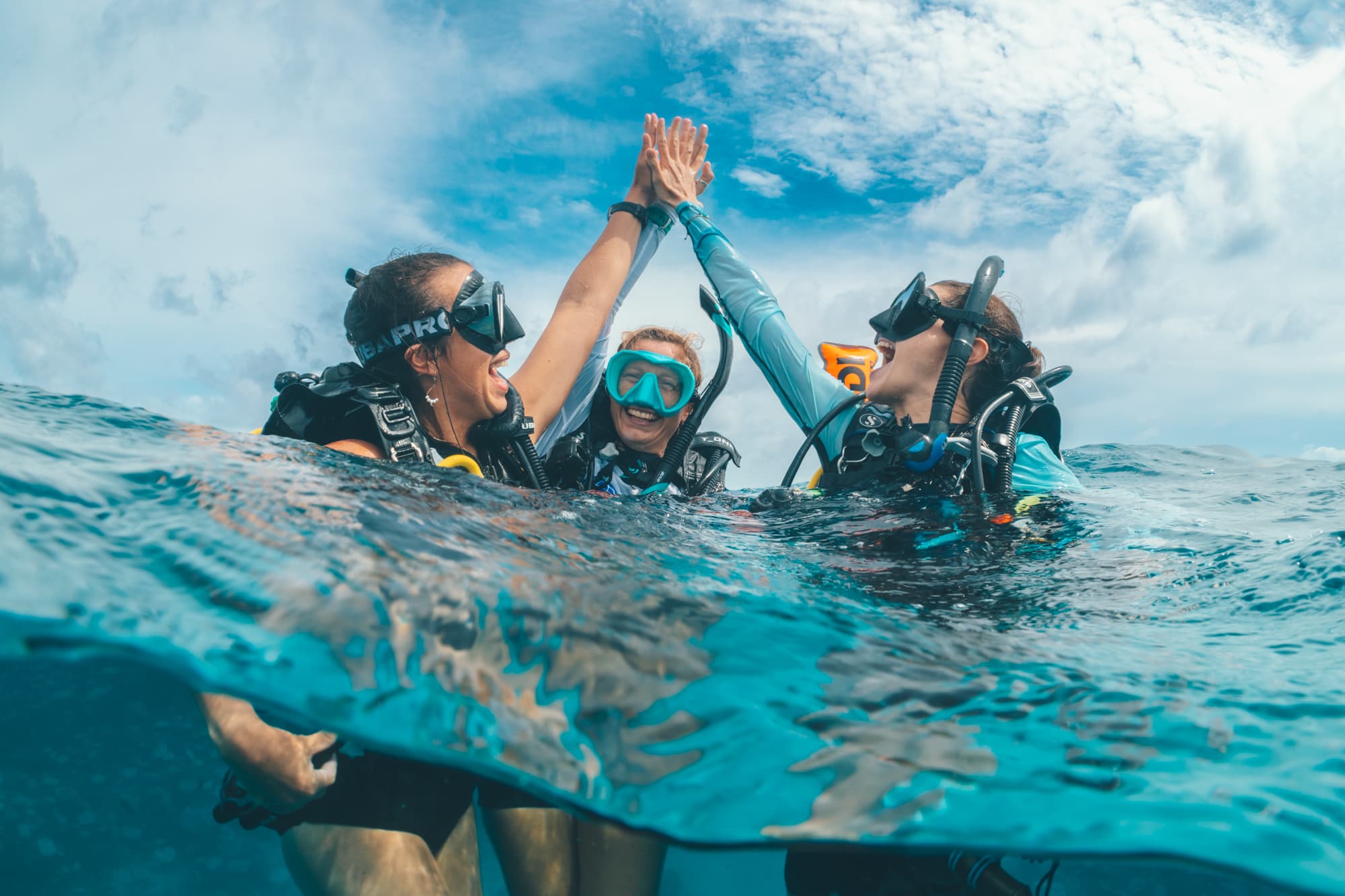 Plongeurs échangeant un high-five à la surface après une plongée